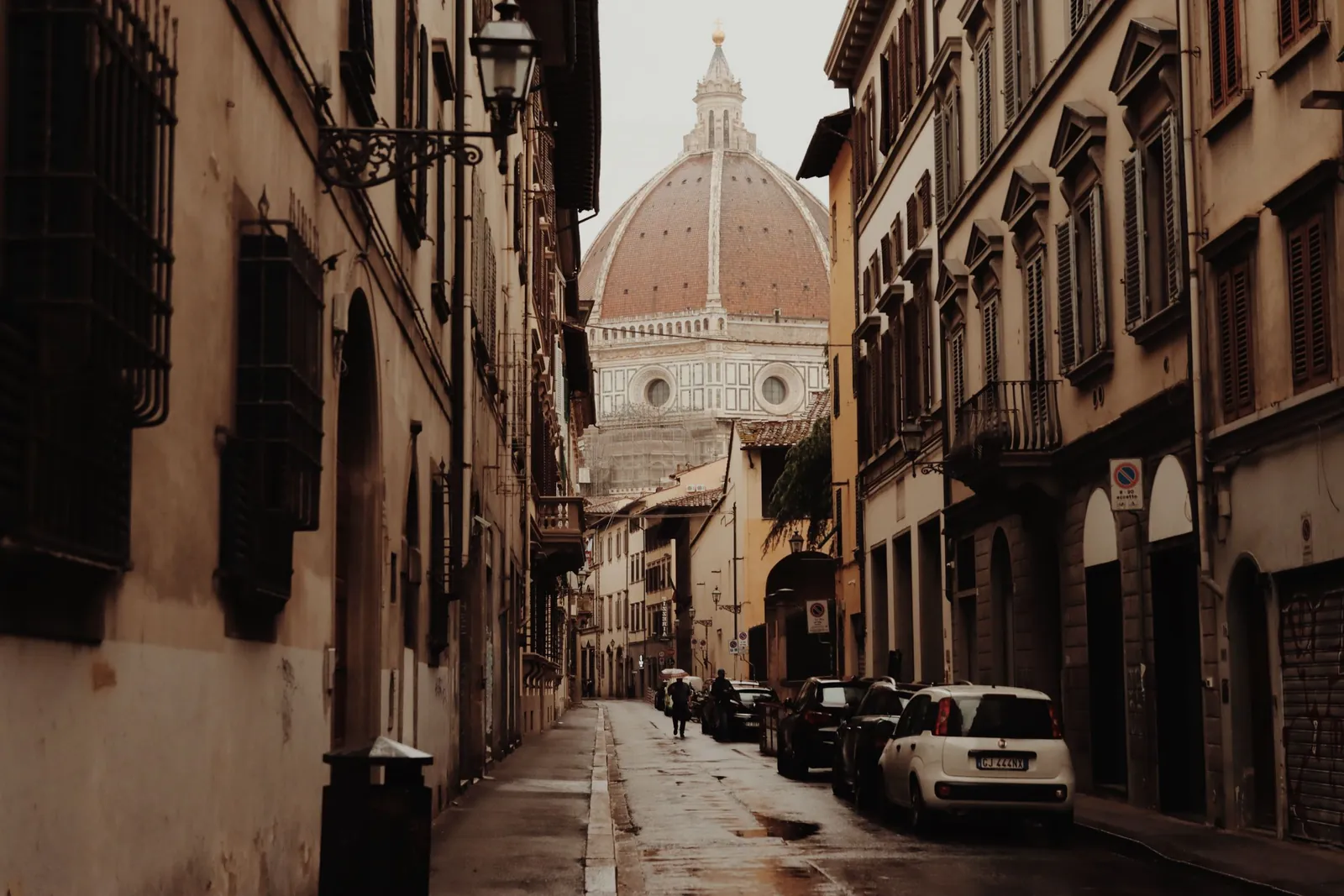 A Florence street on a rainy day, with the Duomo at the end