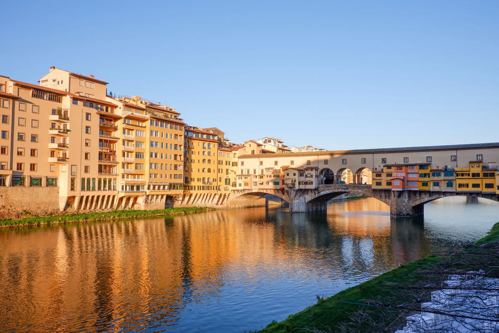 Ponte Vecchio reflected in the Arno at golden hour